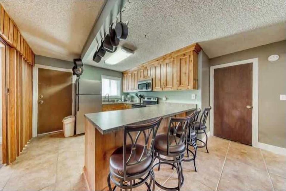 You'll love preparing meals in this spacious, fully equipped kitchen with a charming rustic touch. The large island is perfect for casual dining or socializing while you cook. Appreciate the modern amenities in a cozy setting! (Full kitchen with cooking basics)
