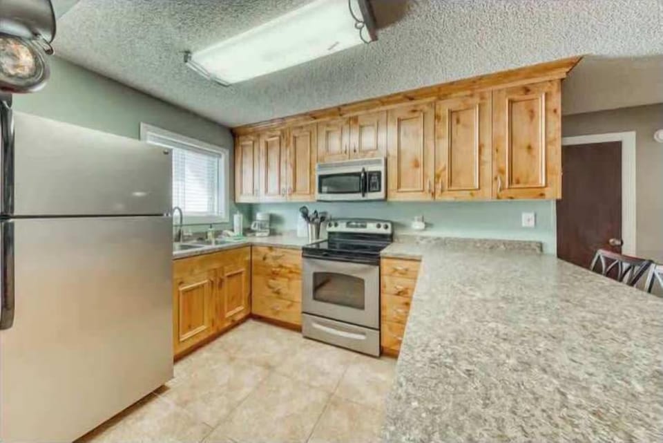 Prepare delightful meals in this charming kitchen, complete with modern appliances and plenty of counter space. You will appreciate the natural wood cabinets and the warm, homey feel they add to your cooking experience. (Full kitchen with modern appliances)