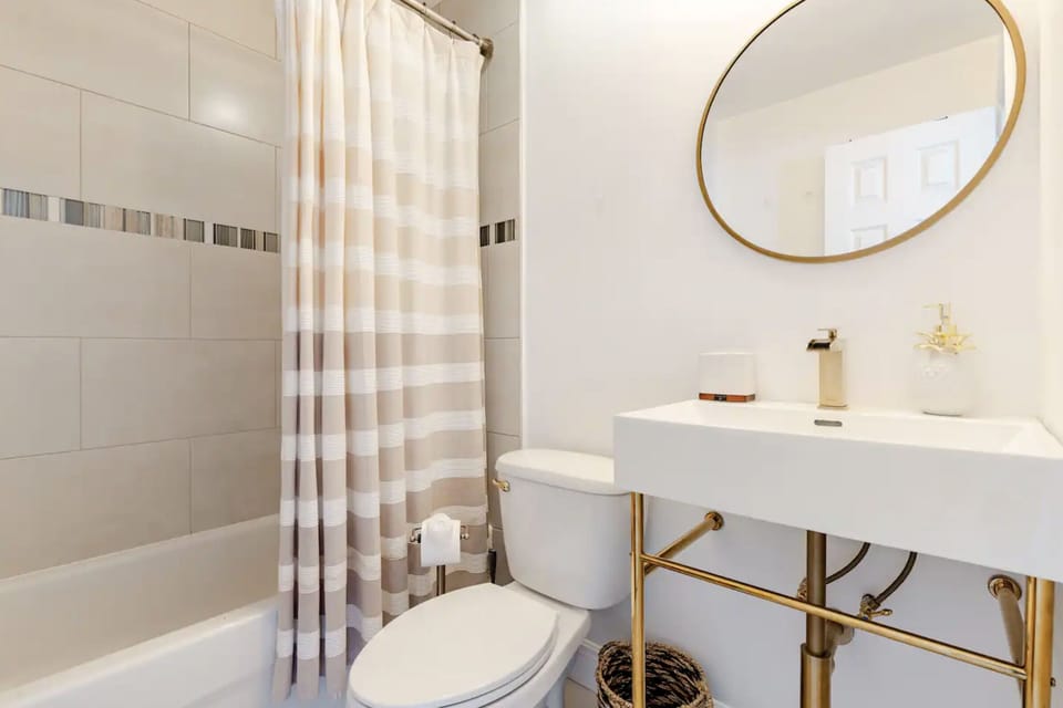 Second full bathroom is equipped with expanded towel rack with stylish sink and mirror.