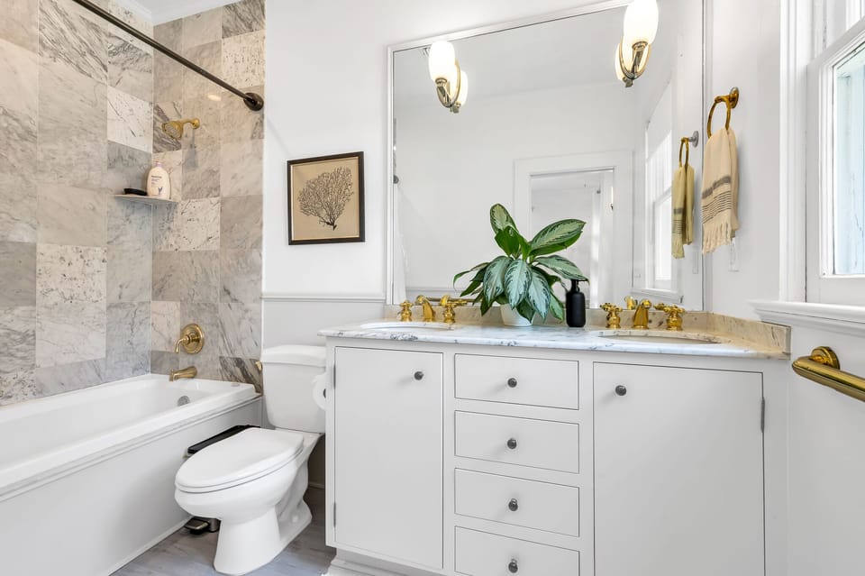 Beautifully upgraded Master bedroom en-suite bathroom with double vanity, combination tub/shower stunning gold fixtures & marbled tiles.