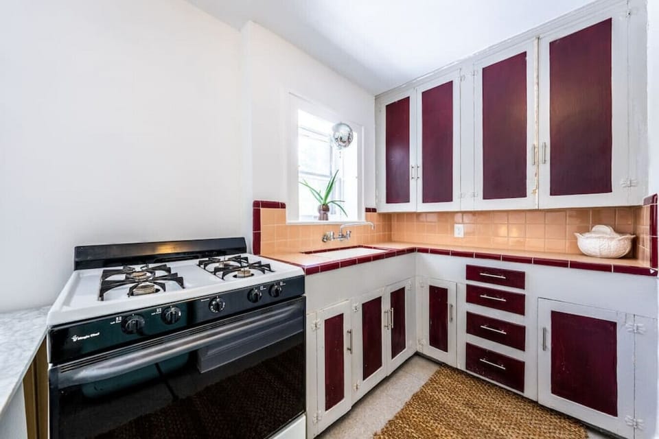 The kitchen includes a sink, lots of cabinet space and dishes, plus a dining table and fridge (and disco ball!)