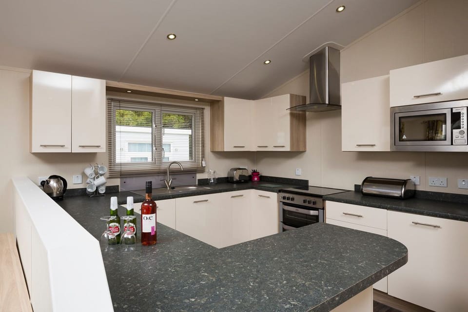 Indulgent Lakeside 8 Berth Lodge + Hot Tub + Private Peg | Private kitchen | Fridge, microwave, oven, stovetop