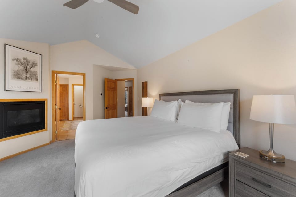 Your peaceful retreat features a plush king bed with crisp linens, cozy fireplace, and soothing neutral tones for ultimate relaxation.