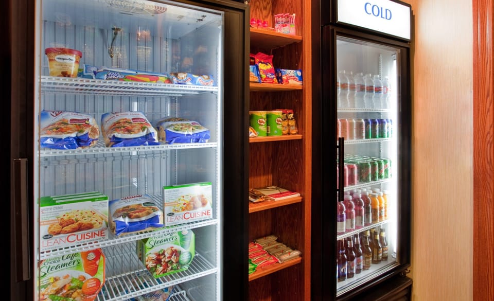 Pantry stocked with refrigerated snacks and beverages.