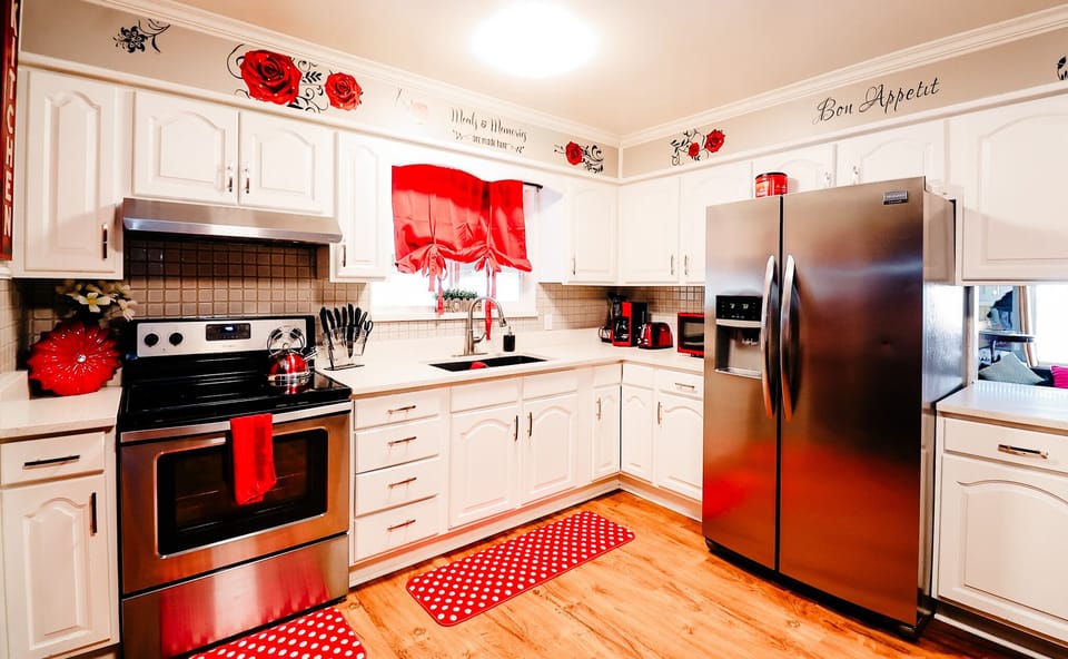 Modern Charm: A Bright and Welcoming Kitchen Accented with Vibrant Red Curtains and Mat 🍽️🔴