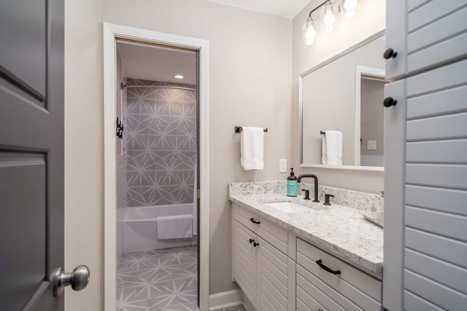 Guest bathroom has plenty of storage and divided with a pocket door.