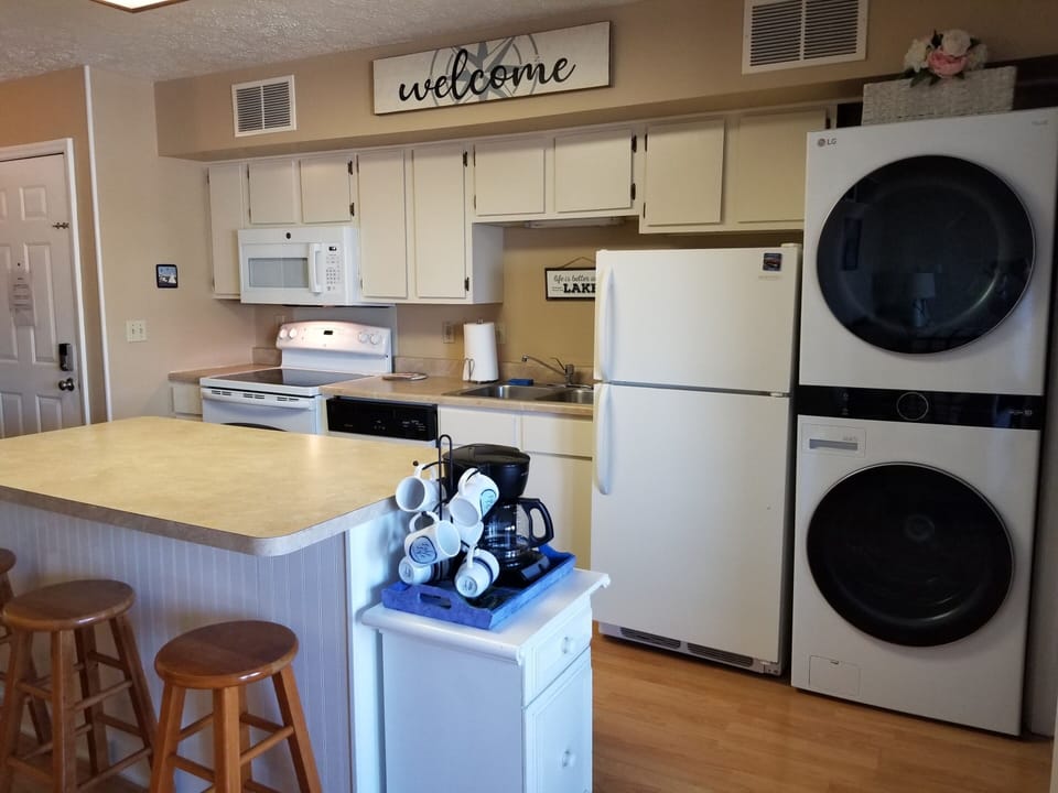 Kitchen area, coffee bar and view of washer and dryer