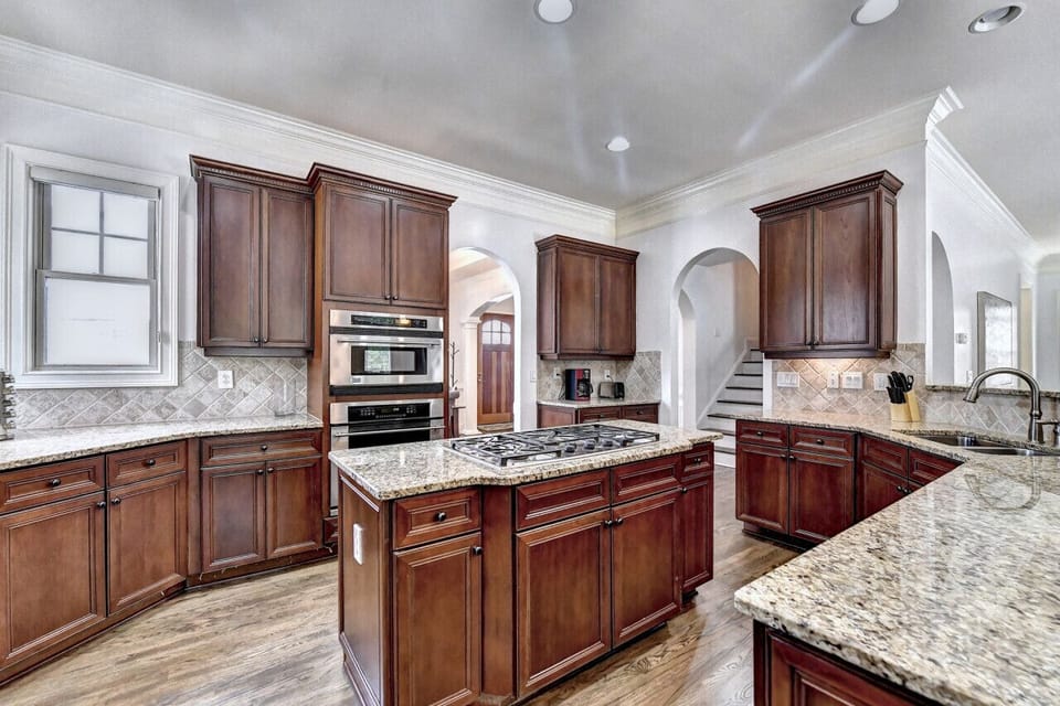 Experience a modern, open-concept living space with a large kitchen, center island, granite countertops, and a stylish dining area, perfect for comfortable and functional living.