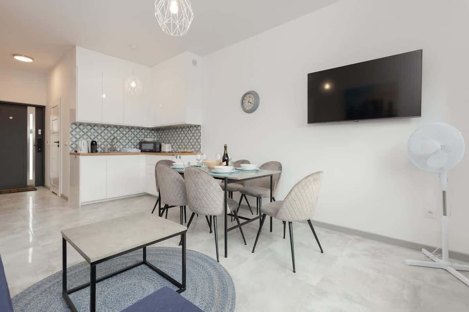 A cozy living area showcasing a wooden staircase, minimalistic decor, and a dining set for a modern family space.