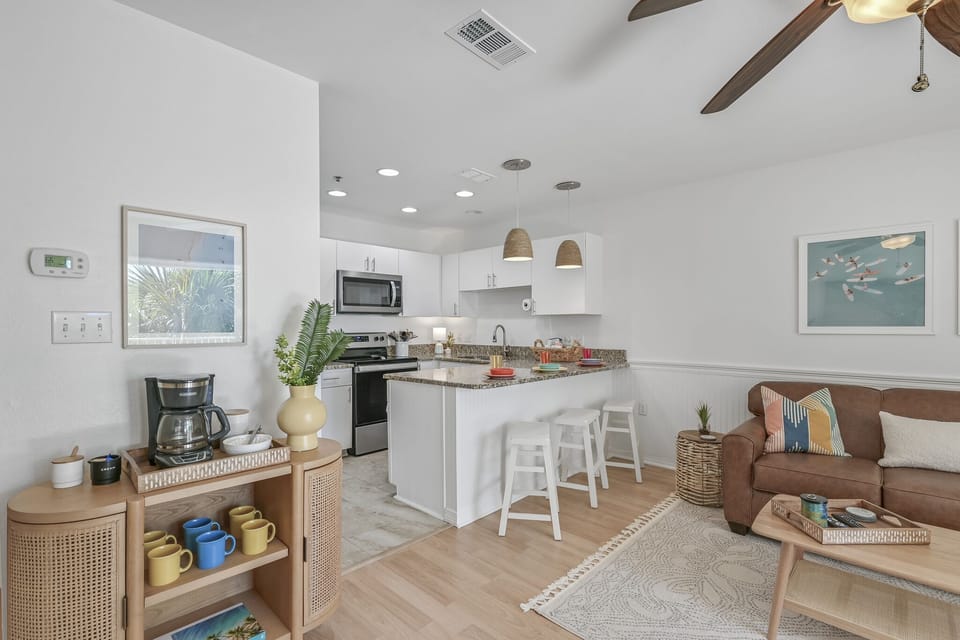 Your modern open-plan kitchen flows seamlessly into the cozy living area, perfect for morning coffee or evening meals together.