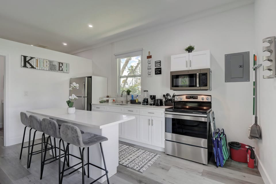 The Kitchen Has a Beautiful Island With 4 Bar Chairs