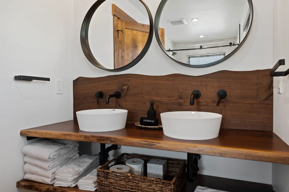 Downstairs en-suite bath includes custom live edge wood vanity and 2 sinks.