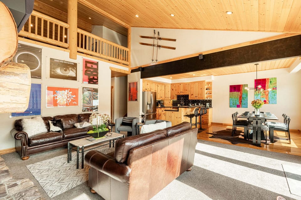 Main Level Living Room with plush leather sofas, contemporary arm chairs, smart tv, gas fireplace, vaulted ceilings, and private hot tub patio access