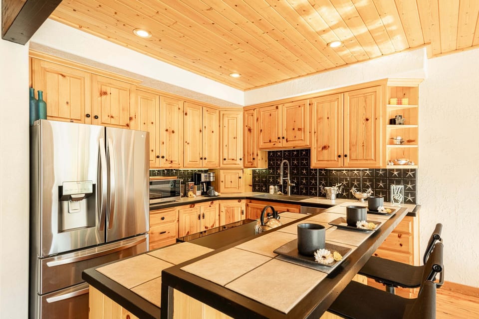 Fully Equipped Kitchen with gorgeous hardwood floors, ice maker, GE appliances, and island seating for three
