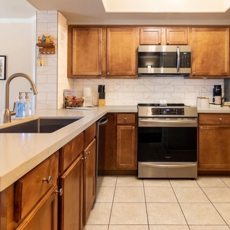 Updated in 2024, the kitchen features a fairly unique design - a wide flat countertop with tons of work space and two counter-height stools. The microwave, range, and dishwasher are 2022 installs. A Keurig coffee maker and supplies are available.