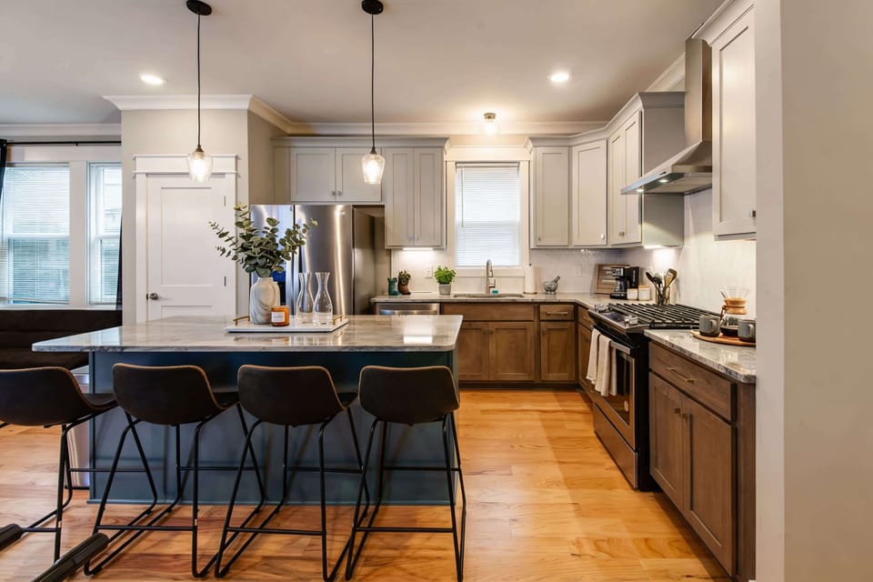 Teal kitchen island with bar seating becomes the gathering spot for morning coffee and late-night snacks throughout your stay