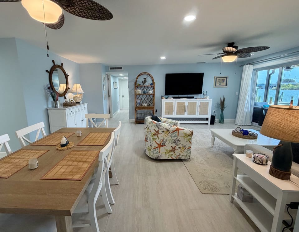 Dining room and living room right beside one another with a wate - Dining room and living room right beside one another with a waterfront view.