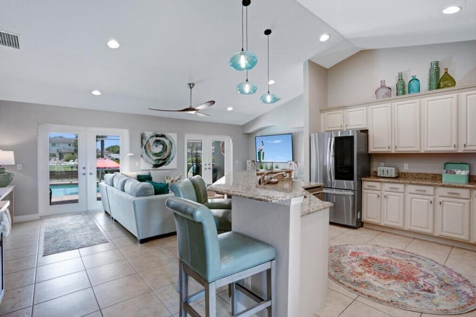 Open-concept kitchen and living area with pool views and modern appliances.