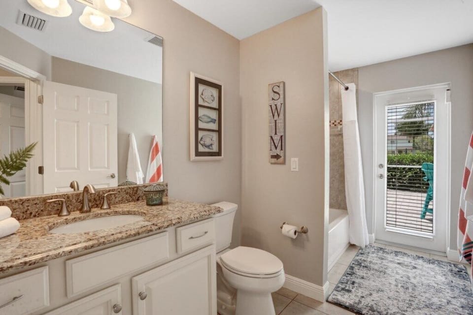 Bright bathroom with granite countertop and patio access for a refreshing start to your day.