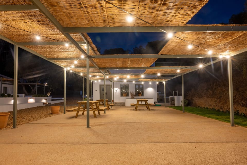 Outdoor area in front of the apartments with shade and barbecue for celebrations.