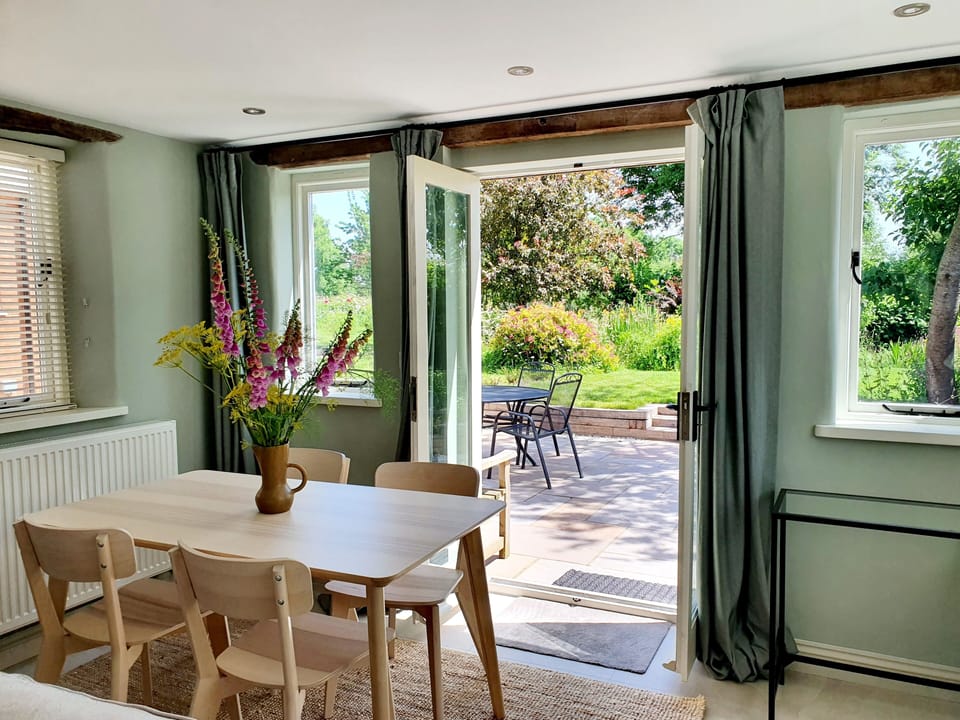 Dining area with French windows leading on to patio and garden.