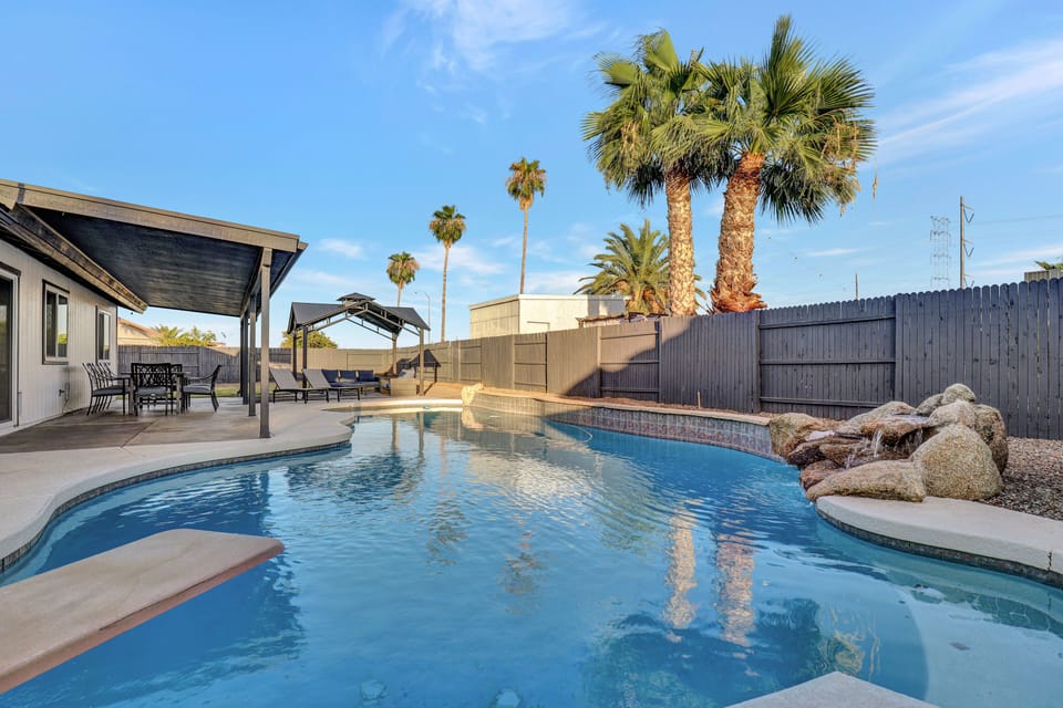Backyard oasis with crystal clear pool, waterfall, covered patio, and gazebo