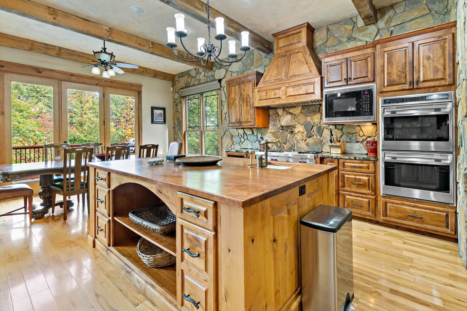 A modern kitchen featuring stainless steel appliances, granite countertops, and ample cabinetry, ideal for preparing meals for family and friends.