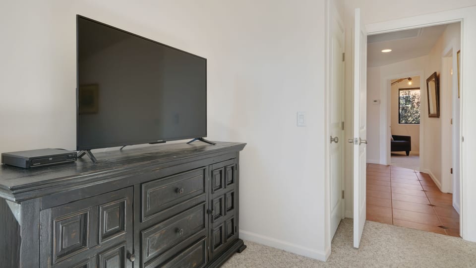 Primary bedroom has king bed, pack n play, TV and large closet