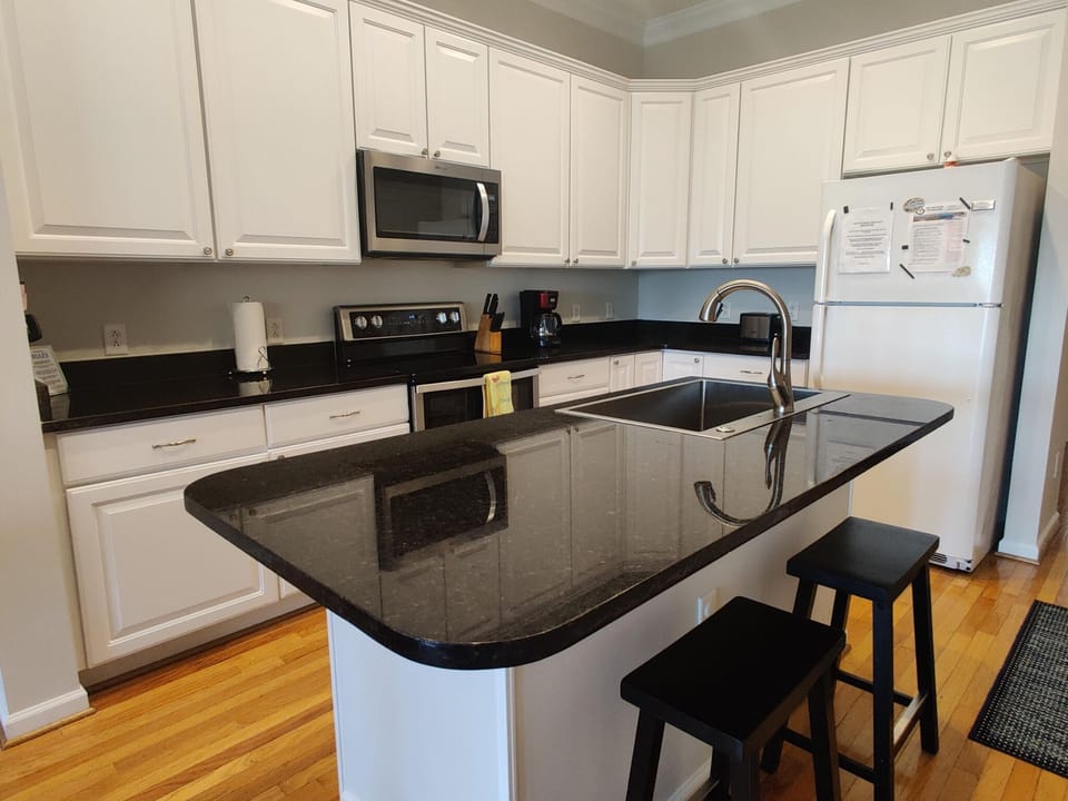 Well equipped kitchen for meal preparation with 2 stools for additional seating.