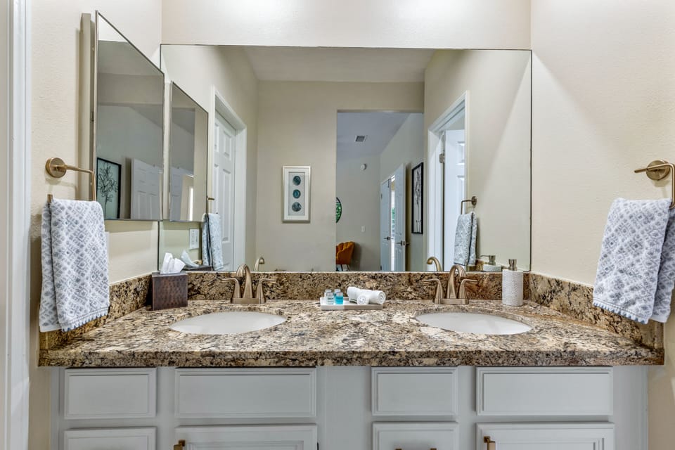 Master bathroom with double sinks and walk in closet