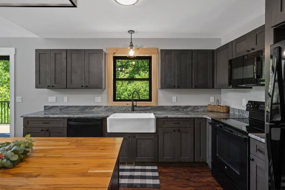 Beautiful farm house sink, modern cabinets and butcher block kitchen island.