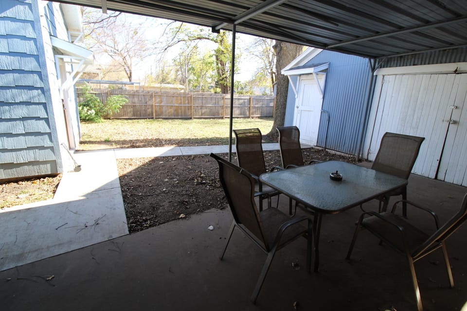 Outdoor covered dining area with charcoal grill.