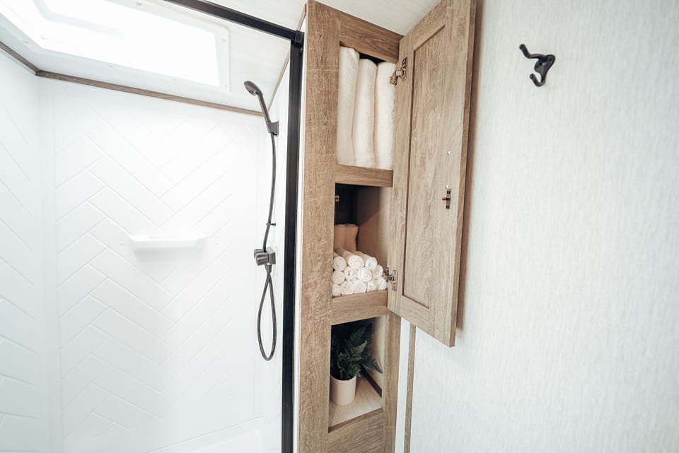 Bathroom is equipped with plenty of towels, hand towels, and wash cloths
