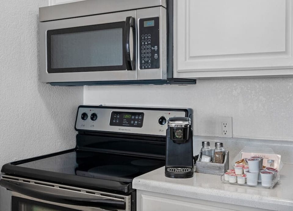 It features a fully equipped kitchen with all the essentials, including a fridge, stove, microwave, and silverware.
