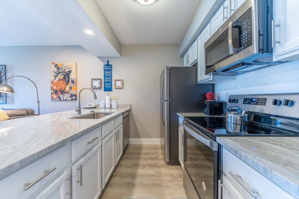 Cook your favorite meals in this fully-equipped galley kitchen featuring modern appliances and elegant granite countertops for effortless meal prep.