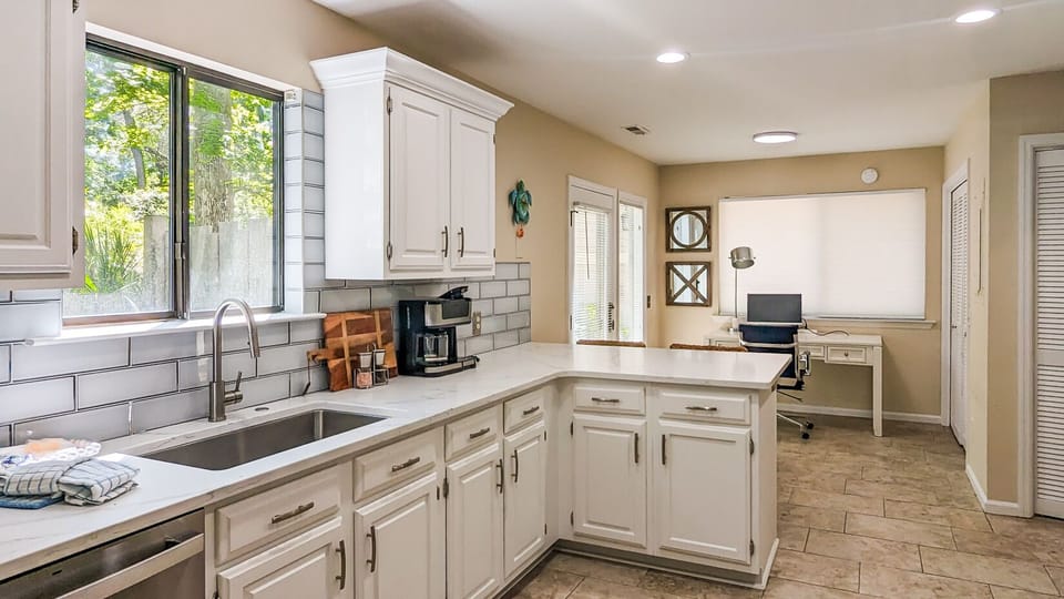 Office area in kitchen with monitor and charging