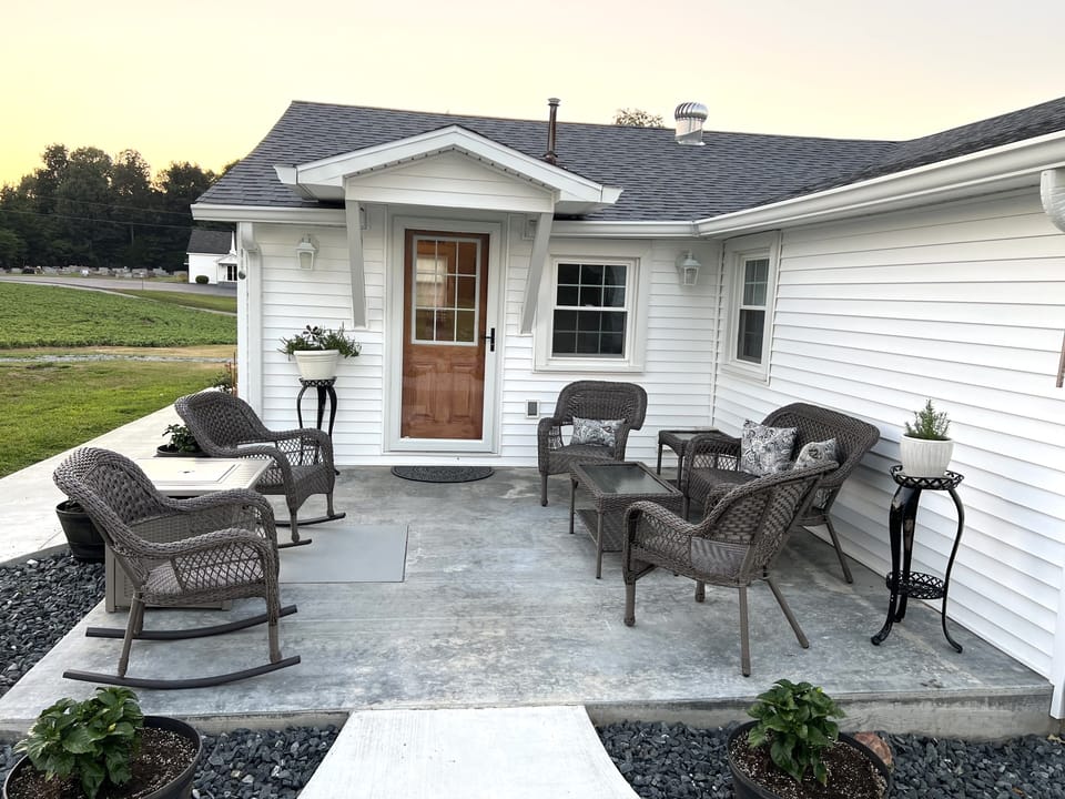 Main entrance to the home.  Patio with comfortable furniture and a fire table