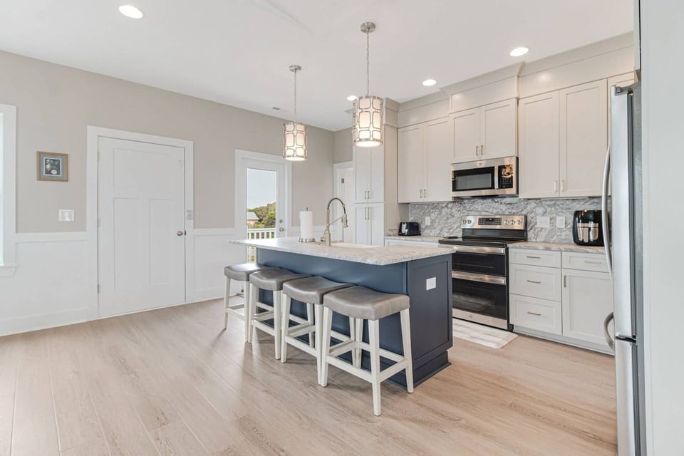 Large open kitchen with 4 cushioned bar stools