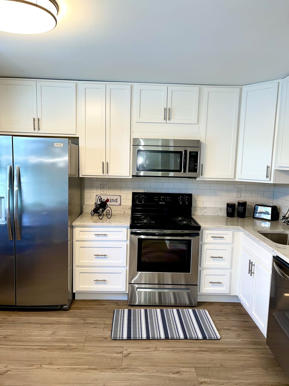 Kitchen includes stainless steel refrigerator, microwave, dishwasher, granite