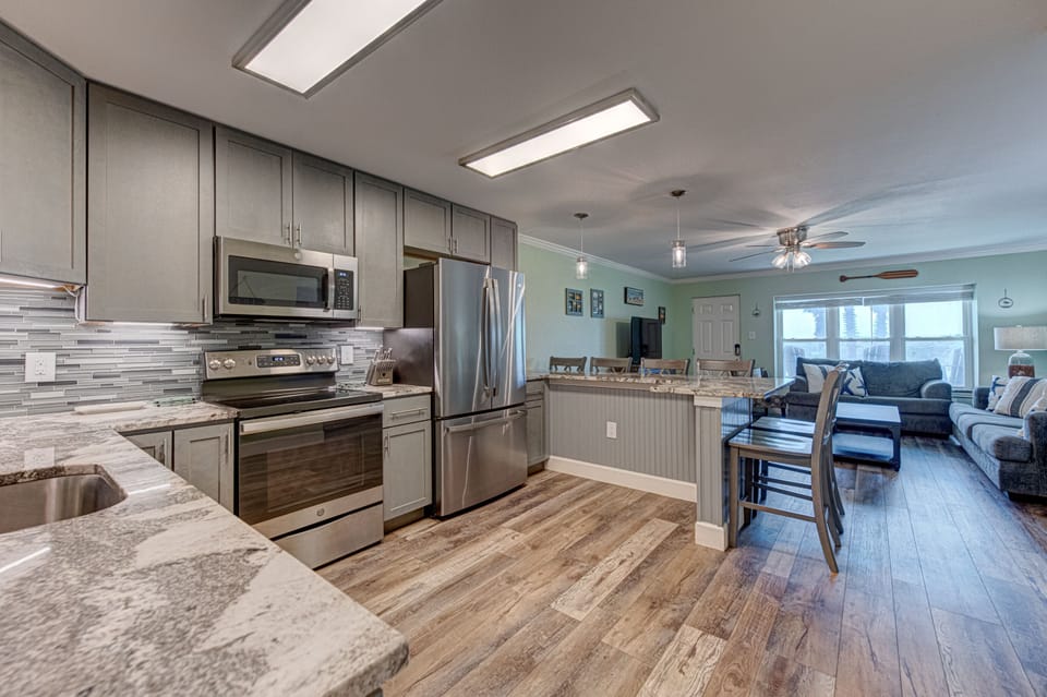 Your fully equipped kitchen flows seamlessly into the living area, perfect for preparing meals while staying connected with your group.