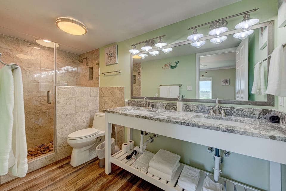 Step into your spa-like bathroom featuring dual vanities, granite countertops, and a gorgeous walk-in shower with travertine tiles.