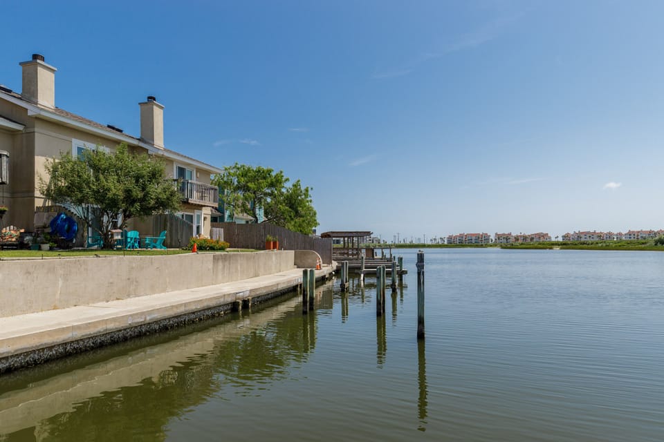 Waterfront property with private dock and boat slip on calm lake waters surrounded by residential community.