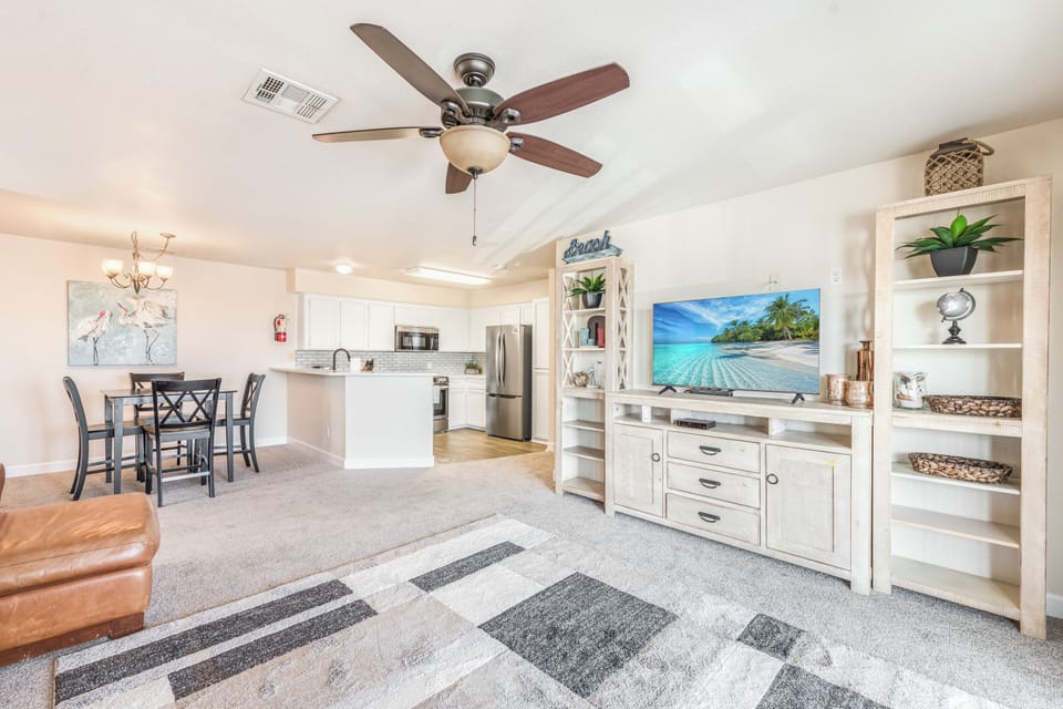 Relax in your bright, open living space with stylish coastal décor, modern kitchen, and tropical beach views on the big screen.
