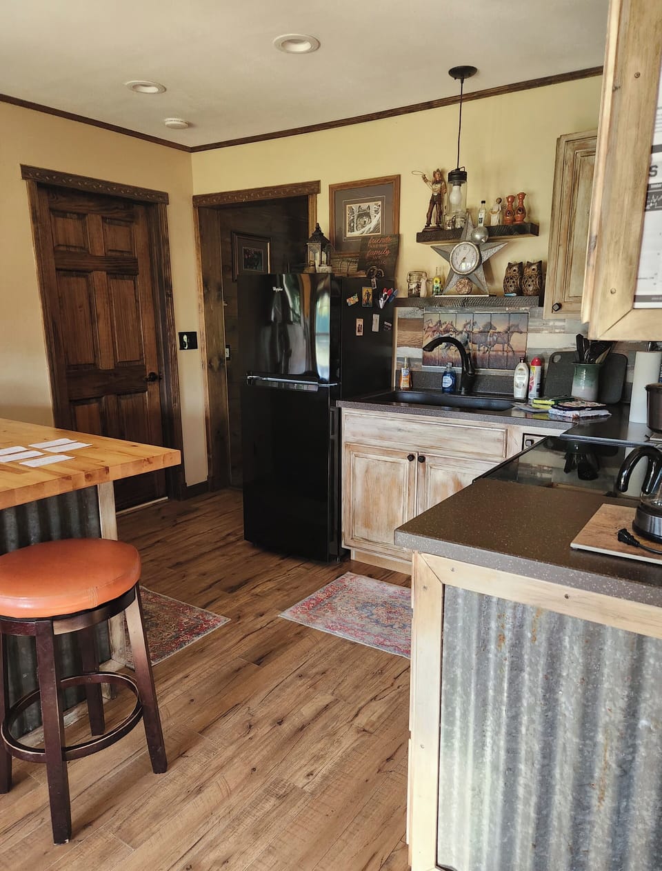 Kitchen area with mid size fridge, full stove, sink, and microwave 