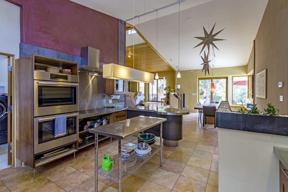 Double oven and stovetop to right, along with a chef's work table.