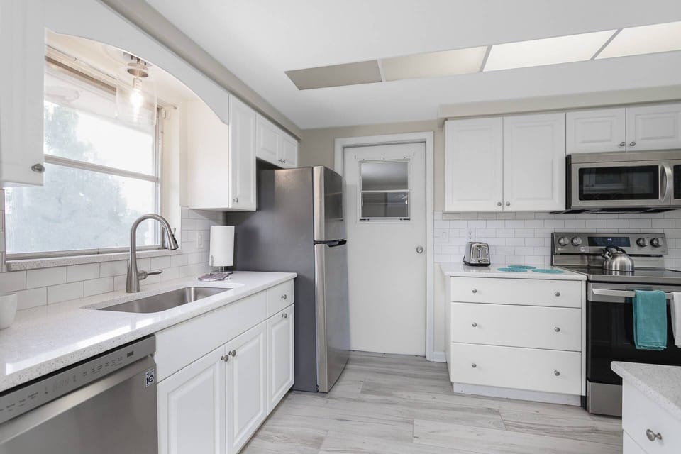 Updated kitchen with new wide plank tile floors and stainless appliances.