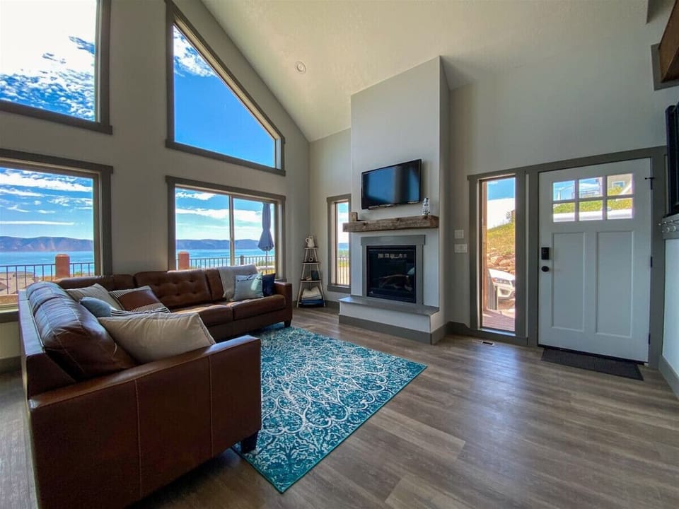Beautiful living room with fireplace, stunning lake views, and abundant natural light—perfect for relaxing.