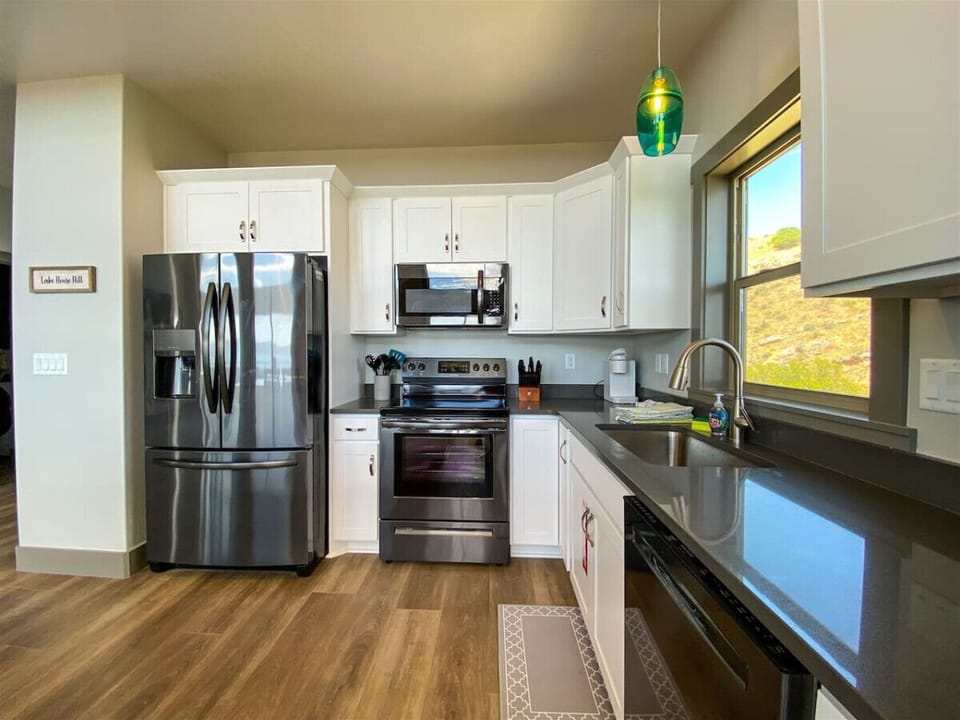 Enjoy cooking with ease in this modern, fully equipped kitchen featuring sleek appliances and scenic views.
