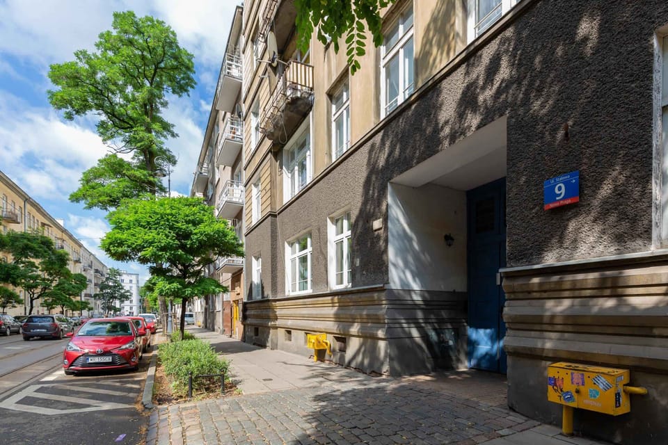 A street view showcasing the building’s exterior and its surroundings. The lush greenery and classic architecture stand out.