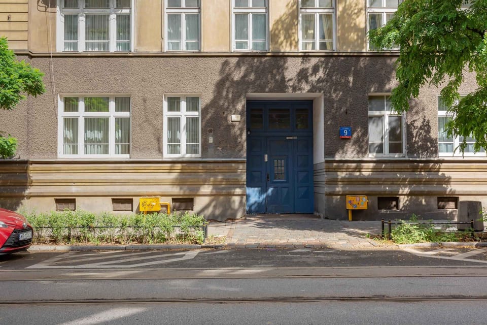  The building entrance surrounded by greenery. A charming exterior with historical details adds character to the property.